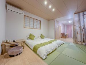 a bedroom with a bed and a desk and a table at 花渓居 绫 in Osaka