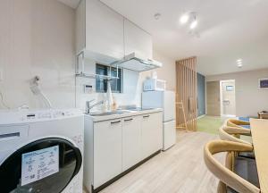 a kitchen with a washer and dryer in a room at 花渓居 绫 in Osaka