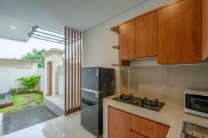 a kitchen with wooden cabinets and a counter top at Villa Latsu Canggu in Canggu