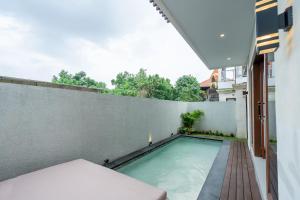 a swimming pool on the balcony of a building at Villa Latsu Canggu in Canggu