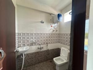 a bathroom with a toilet and a sink at K P M Lodge in Atmakūr
