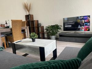 a living room with a table and a tv at Ferienhaus Kusel - am Bahnhof mit WLAN & Garten in Kusel