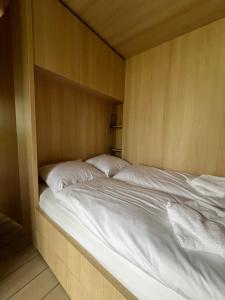 a large bed in a wooden room at Capsula aan de Wadi in Diepenheim