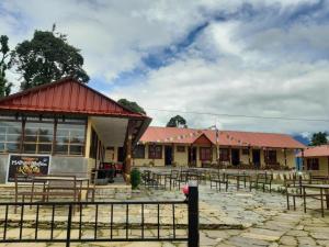 ein Gebäude mit Tischen und Stühlen davor in der Unterkunft Hotel mardi station and restaurent in Astam
