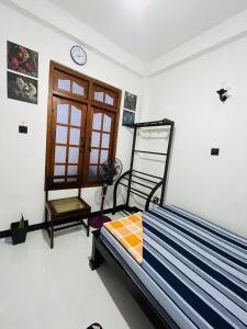 a bedroom with a bed and a clock on the wall at Suriya Haven Homestay in Badulla +26 photos