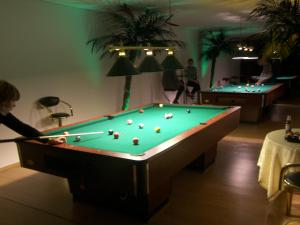 a man playing pool in a room with two pool tables at Hotel Dlugie in Strzelce Krajeńskie