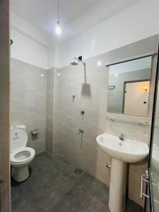 a bathroom with a toilet and a sink and a mirror at Suriya Haven Homestay in Badulla