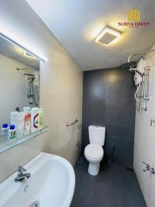 a bathroom with a white sink and a toilet at Suriya Haven Homestay in Badulla