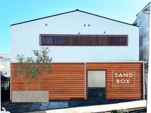 ein Sandwich-Box-Gebäude mit einem Schild mit der Aufschrift „Sandwich-Box“ in der Unterkunft SANDBoX in Oshima