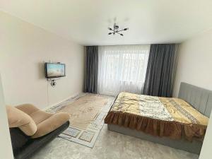 a bedroom with a bed and a tv in it at Kabay 7 in Semey