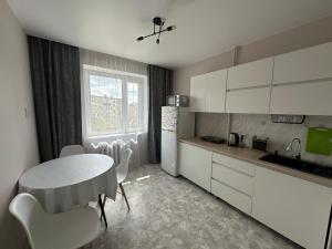 a kitchen with a table and a table and chairs at Kabay 7 in Semey
