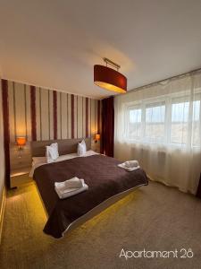a bedroom with a large bed with two towels on it at Apartamente Baile Felix in Baile Felix