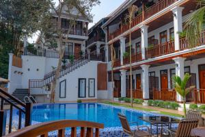 a hotel with a swimming pool in front of a building at Dream1985 Hotel in Luang Prabang