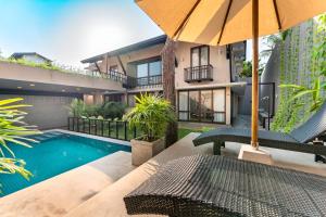 an apartment patio with a swimming pool and an umbrella at Lush Royale Villa Kotte with Pool & Gym in Sri Jayewardenepura Kotte