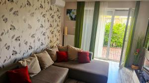 a living room with a couch and a window at Koczor Apartman in Balatonfüred