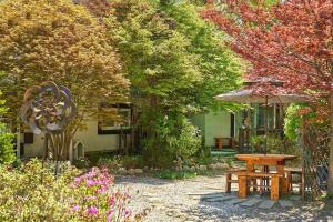 a garden with a wooden table and an umbrella at Arajin Pension in Yangpyeong