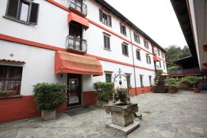 a white building with a red awning and a courtyard at Il Castello B&B in Varallo Pombia
