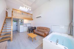 a living room with a tub and a couch at Gangneung Atirance Pool Villa & Spa Pension in Gangneung +4 photos