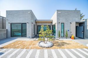 una casa con un albero davanti di Peer Haus Private House a Gangneung