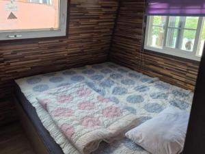 une petite pièce avec un lit avec une couverture dessus dans l'établissement Cheongdo Provence Light Festival Caravan Pension, à Cheongdo