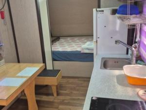 une petite pièce avec un lavabo et un petit lit dans l'établissement Cheongdo Provence Light Festival Caravan Pension, à Cheongdo