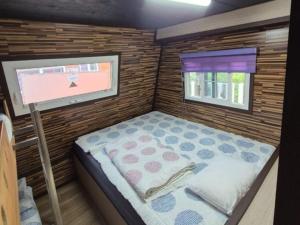 une petite pièce avec un lit et une fenêtre dans l'établissement Cheongdo Provence Light Festival Caravan Pension, à Cheongdo