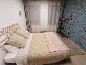 a bedroom with a bed and a wall with flowers at L'Atelier des Rêves in Saverne