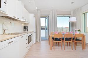 uma cozinha com mesa e cadeiras e uma sala de jantar em Forenom Serviced Apartments Tampere Pyynikki em Tampere