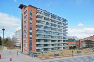 a tall red brick building in a city at Forenom Serviced Apartments Tampere Pyynikki in Tampere