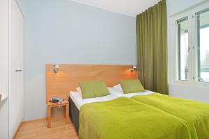 a bedroom with a green bed with a window at Forenom Serviced Apartments Tampere Pyynikki in Tampere