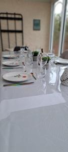 a white table with glasses and plates on it at Gite le nid du canal in La Celle-sous-Gouzon +17 photos
