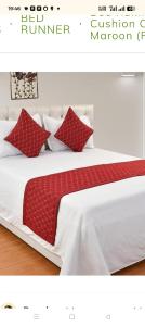a bedroom with a bed with red pillows on it at SMS GRAND inn in Chennai