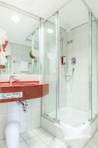 La salle de bains est pourvue d'une douche et d'un lavabo. dans l'établissement Hotel am Schillerpark, à Esslingen am Neckar
