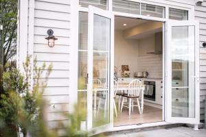 a sliding glass door leading to a kitchen with a table at 3 Bed Family Retreat Classic Charm With Park Views in Christchurch +43 photos