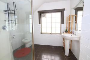 Un baño con inodoro, lavabo y ducha. en Historic English Manor in New Town, en New Town