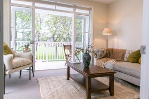 a living room with a couch and a table at 3 Bed Family Retreat Classic Charm With Park Views in Christchurch