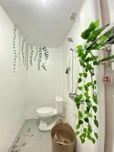 a bathroom with a toilet and a potted plant at Inn Convenience in Coron