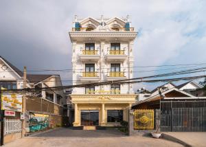 a tall white building with balconies on a street at Quỳnh Phương Villa Đà Lạt in Ấp Kim Thạch