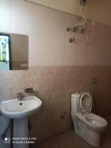 a bathroom with a toilet and a sink at Hotel Food Mania in Ner Chowk