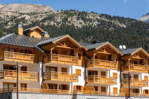 un gran edificio con una montaña en el fondo en CGH Résidences & Spas Le Napoléon, en Montgenèvre