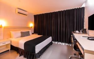 een hotelkamer met een bed en een bureau bij Citi Boutique Hotel - Lahara Avenue in Port Moresby