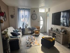 a living room with a couch and a tv at Maison idéalement située à Boulogne sur mer, Gite La Vie Est Belle in Boulogne-sur-Mer
