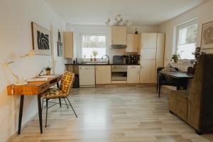 une cuisine avec un bureau, une table et un canapé dans l'établissement 40qm Wohlfühl-Apartment im Grünen mit Sorglospaket, à Wuppertal
