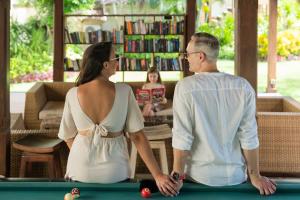 a man and a woman sitting next to a pool table at Vila Ombak in Gili Trawangan