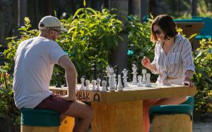 a man and a woman playing chess on a table at Vila Ombak in Gili Trawangan