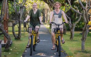 two people riding bikes down a path at Vila Ombak in Gili Trawangan
