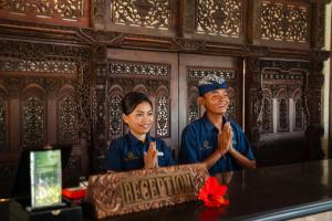 a man and a woman standing next to a table with a cake at Vila Ombak in Gili Trawangan