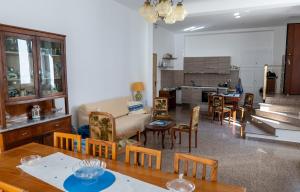 a living room with a table and chairs and a kitchen at Casa Meraviglia del mare in Capo dʼOrlando