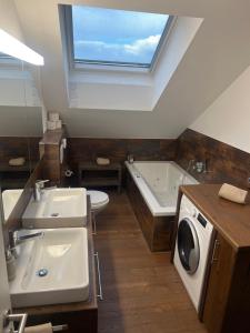 a bathroom with two sinks and a tub and a washing machine at Restaurant Hammer Highway-Grill in Lucerne