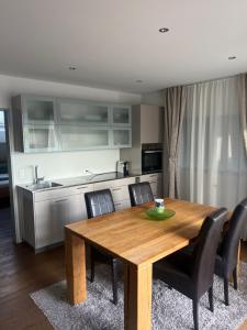 a dining room table with black chairs and a kitchen at Restaurant Hammer Highway-Grill in Lucerne